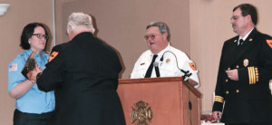 Firefighter Sherra Deimeke receives her 20 Year Service Award of a Bronzed Axe from Deputy Chief Steve Gentry with Chief Kenneth Hoover and Assistant Chief Bill Albus.